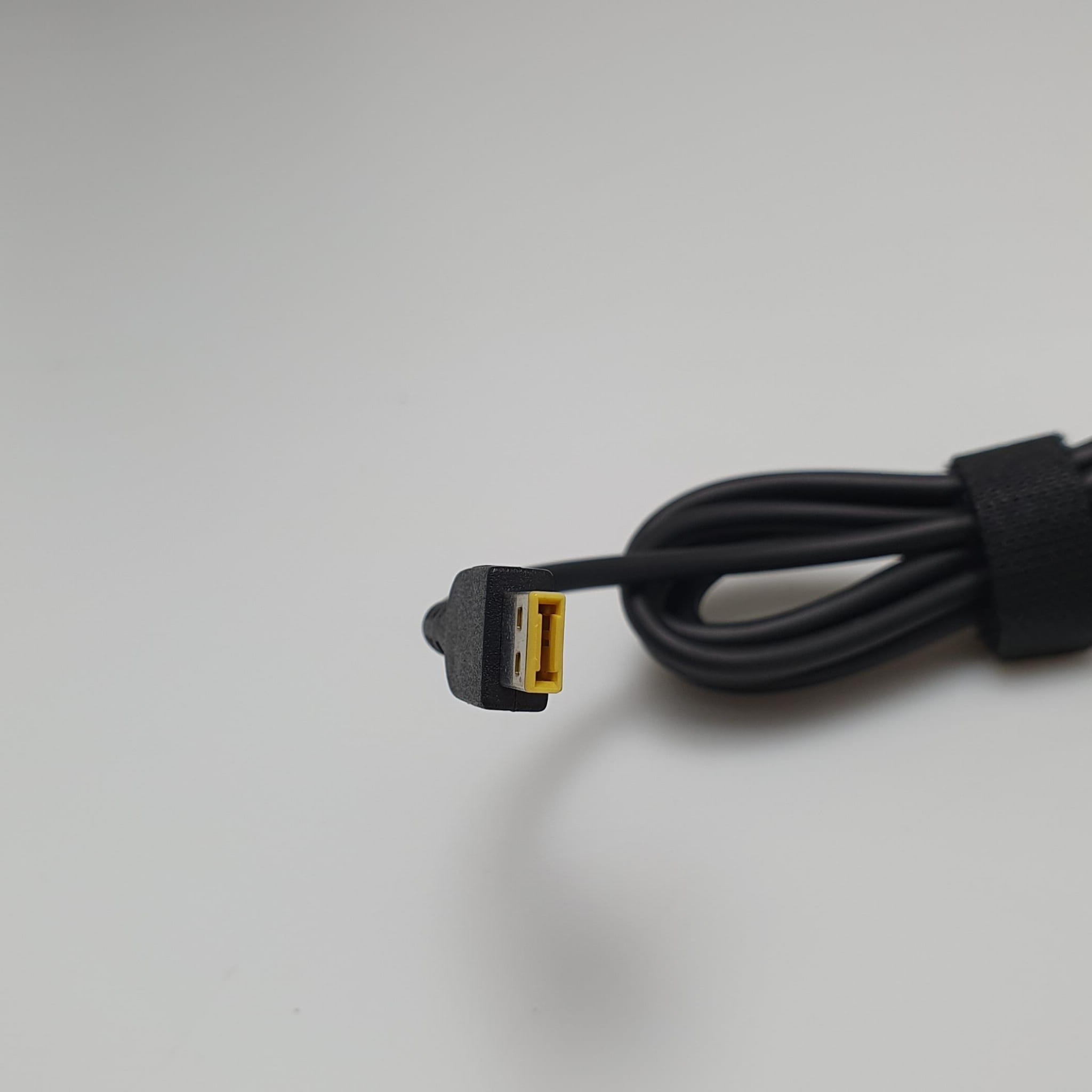 Zasilacz Lenovo 10 12V Zamiennik 36W 2 Zbliżenie żółtej prostokątnej końcówki przewodu zasilacza samochodowego Lenovo
