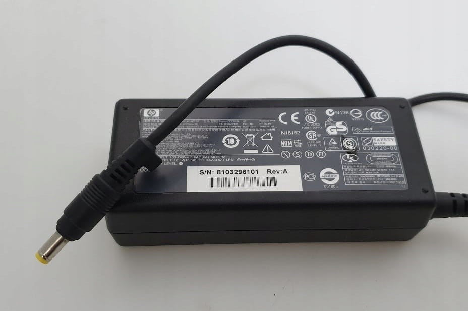 Zasilacz HP 18.5V 3.5A 65W PA-1650-02HP 4 Spód czarnego zasilacza HP z etykietą parametrów oraz przewodem z żółtą końcówką