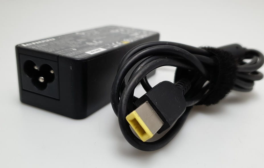 Zasilacz Lenovo 20V 2.25A 45W 4 Zbliżenie zasilacza Lenovo z przewodem i prostokątną żółtą końcówką